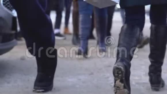 城市人群的双脚特写冬天成群的人脚踩着肮脏的雪城市视频的预览图