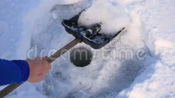为冬季捕鱼和铲雪提供冰钻洞的特写视频的预览图