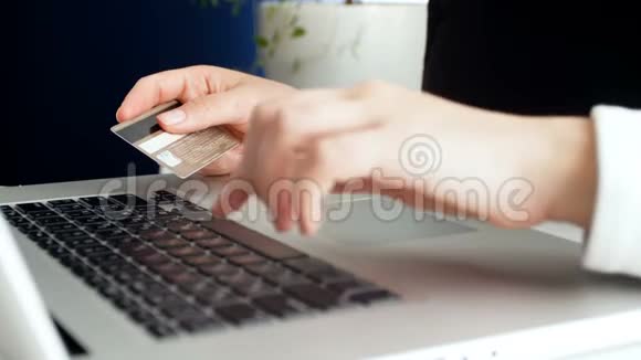 特写4k镜头拍摄奥永女士在笔记本电脑上进行网上购物并输入信用卡号码视频的预览图