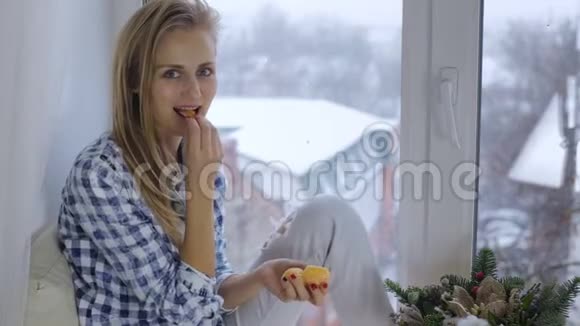 女人吃橘子看着镜头视频的预览图