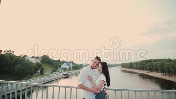 一对相爱的夫妇站在一座桥上对抗蓝天视频的预览图