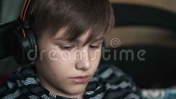 男孩通过耳机听音乐视频的预览图