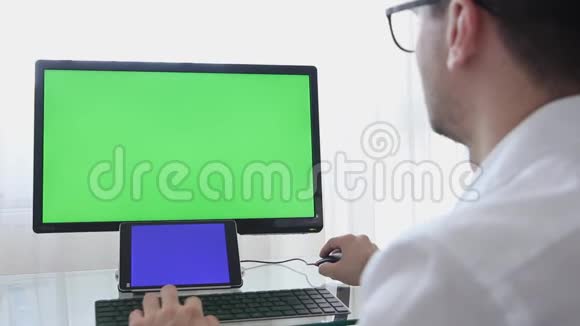 眼镜工程师建筑工程师设计师在个人电脑上工作显示器上有绿色屏幕视频的预览图
