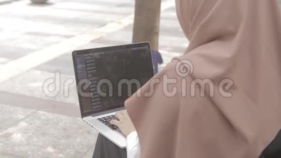 有笔记本电脑的女人坐在公园的长凳上视频的预览图