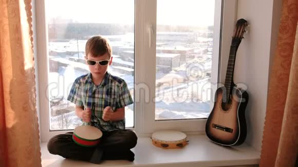 演奏乐器男孩坐在窗台上打鼓视频的预览图