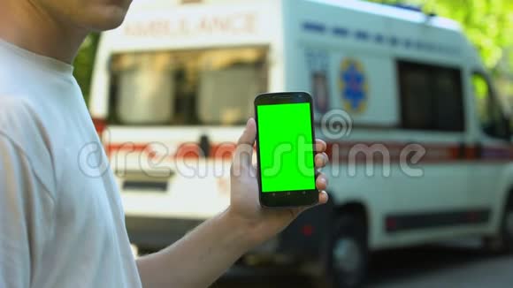 男性手持手机背景救护车申请紧急呼叫视频的预览图