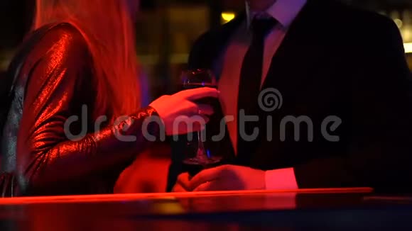 在夜总会和男人调情的年轻女子一对正在喝酒的情侣视频的预览图