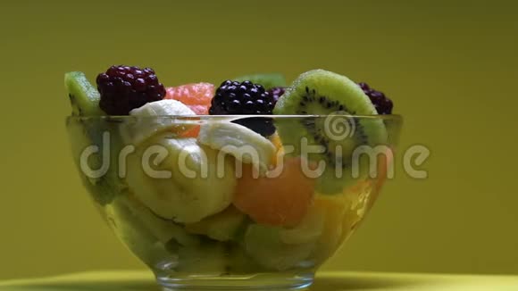 玻璃碗中的新鲜水果在桌子上旋转维生素化的甜沙拉视频的预览图