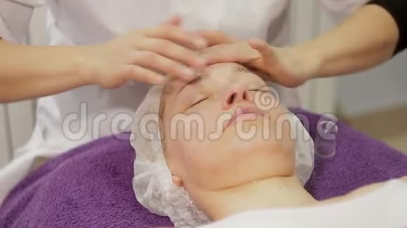 在美容师的办公室里一位40岁的妇女正在做手术面部按摩视频的预览图