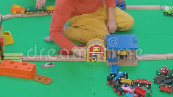 小男孩在地板上玩木铁路视频的预览图