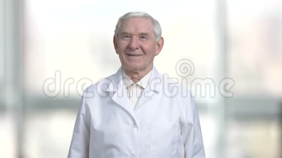 老爷爷穿着白衬衫和外套微笑着视频的预览图