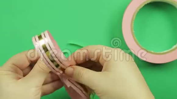 女性的手在绿色的背景上形成一条粉红色丝带的空白视频的预览图