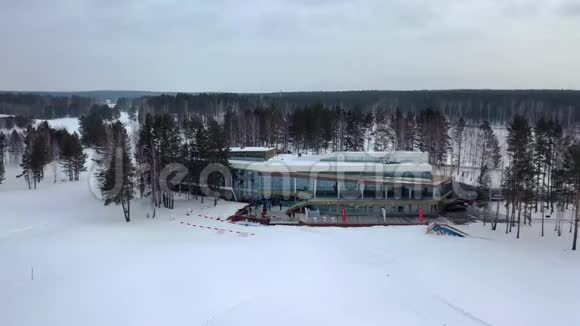 冬季娱乐中心的俯视图录像美丽的冬季度假基地树木环绕游客云集视频的预览图
