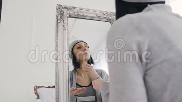 一个时髦的女人看着大镜子化妆视频的预览图