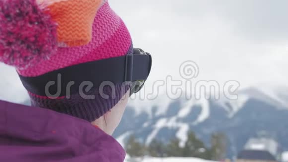 坐在山顶上享受山景的滑雪板女孩雪山上的运动女人美丽动人视频的预览图