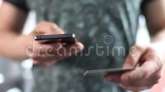 一个男人用他的手机和信用卡在网上购买礼物智能手机网上银行视频的预览图