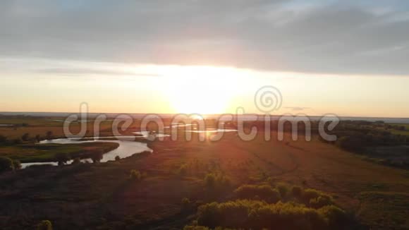 日落时乡村池塘和田野的迷人景观视频的预览图