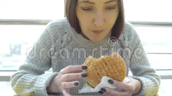 年轻女人吃汉堡有害脂肪食物视频的预览图