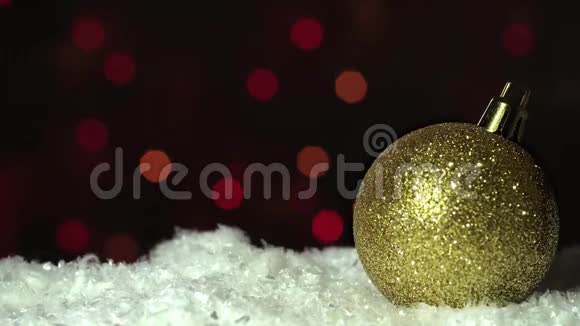 圣诞节装饰金球雪在模糊的背景上视频的预览图
