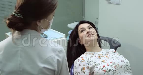 牙科医生说病人坐在牙科医生的手上牙科护士正在让病人做好准备开始工作视频的预览图