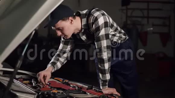 汽车服务维修保养和人员概念在车间工作时穿工作服和戴帽的技工视频的预览图