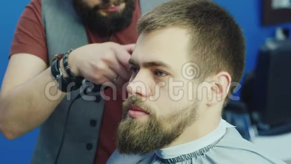 时尚留胡子的理发师在男士沙龙理发视频的预览图
