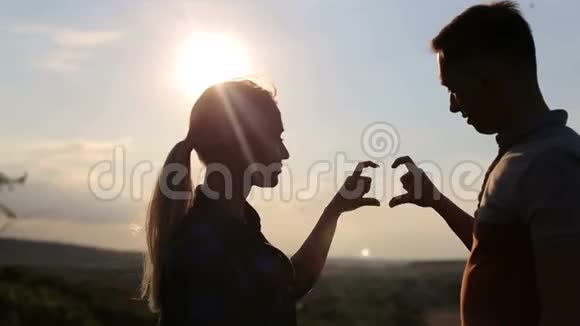 双手在日落时形成心形剪影视频的预览图