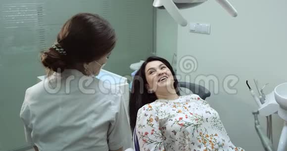 牙医与病人交谈牙科护士站在旁边病人微笑着4k视频的预览图