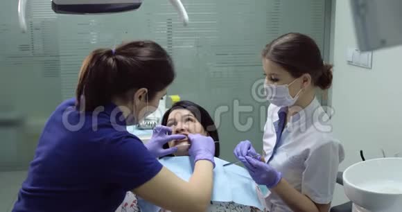 牙科医生的病人张开嘴看着镜子看着牙医视频的预览图