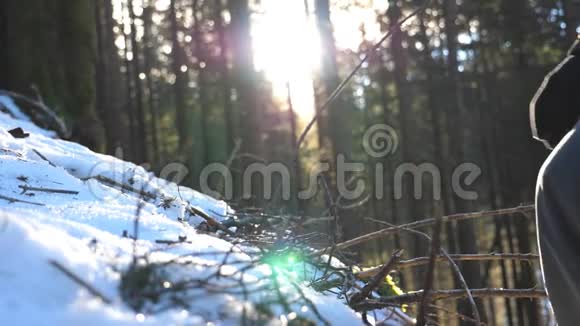 阳光明媚的一天一个年轻的徒步旅行者在雪山上爬山无法辨认的人在雪地上徒步视频的预览图