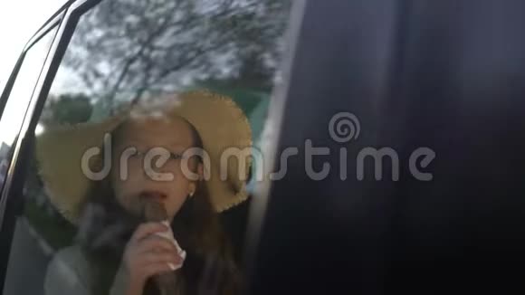 小美女在车后座吃巧克力甜甜圈公路旅行概念视频的预览图
