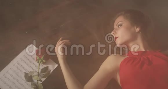 一个红唇的悲伤女孩躺在黑暗的地板上烟雾弥漫视频的预览图
