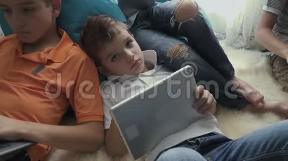 兄弟一家人把闲暇时间花在家里的笔记本电脑和平板电脑上视频的预览图