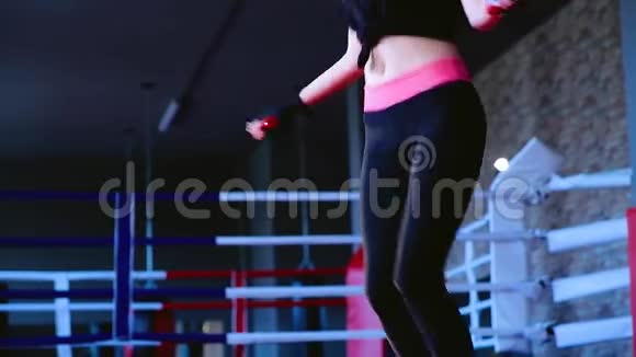 运动缓慢身材苗条的年轻女子运动员穿着黑色运动服跳上绳子和训练视频的预览图