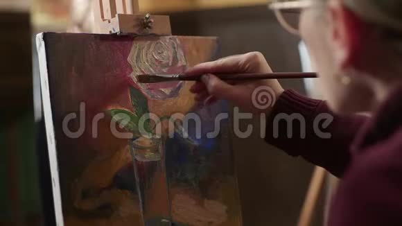 女人用油在画布上画一朵玫瑰妇女小组视频的预览图