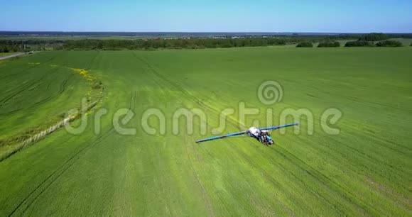 空中摄像机俯视着广阔的田野有着拖着的喷雾器视频的预览图