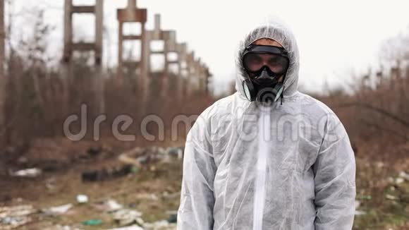 穿着生物危险服和防毒面具的人站在工厂前面视频的预览图