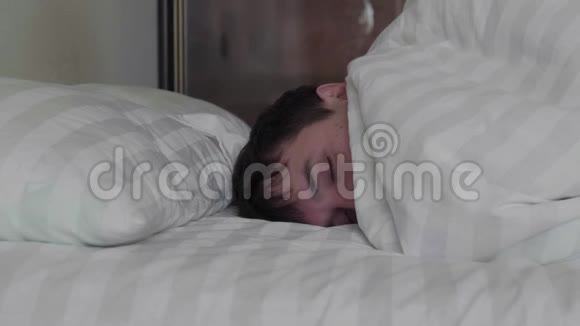 睡觉的人在双人床上用柔和的环境光线做梦时转向光线相机在臂架上移动侧面视频的预览图