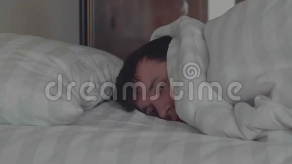 睡觉的人在双人床上用柔和的环境光线做梦时转向光线相机在臂架上移动侧面视频的预览图