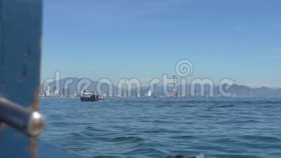 海上浮船城市景观和蓝天背景上的索道景观漂浮在蓝色海洋中的海船视频的预览图