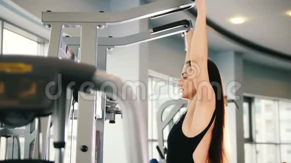 有魅力的年轻女性在健身房锻炼肩膀训练视频的预览图