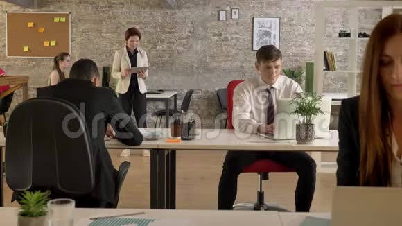 在办公室工作的混合种族的商界人士突然有一个白人开始欢呼和跳舞每个人视频的预览图
