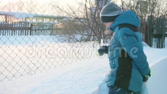 冬天公园里的一个少年在雪地里画一根冰柱下雪的霜天晴天新鲜空气中的乐趣和游戏视频的预览图