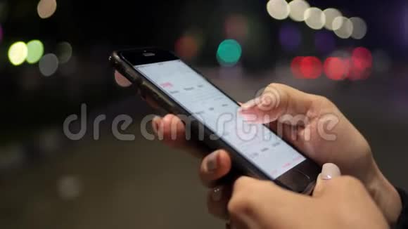 女孩手滚动日历上一个黑色的大智能手机打字夜光上的城市反射概念视频的预览图
