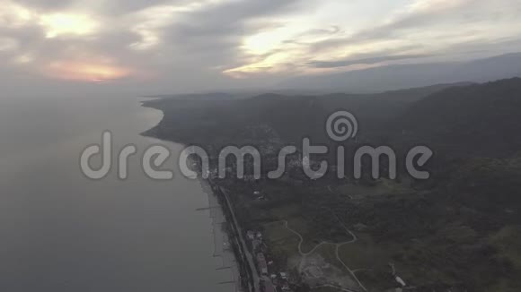 无人机摄像机显示黑海海岸线日落时的青山和多云的天空视频的预览图