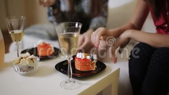 两个女人在家里的沙发上聊天喝酒吃蛋糕视频的预览图