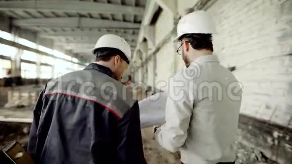顾客戴着防护头盔核实建筑工人对正在施工的物体的工作人们走过视频的预览图