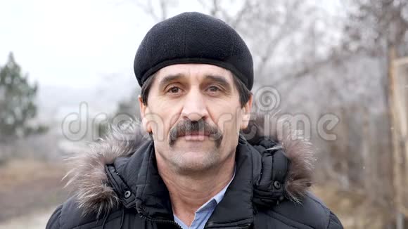 50多岁的欧洲男子戴着帽子对着镜头微笑的肖像视频的预览图