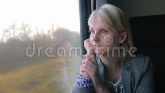 商务妇女坐火车去望着窗外的春天景色视频的预览图