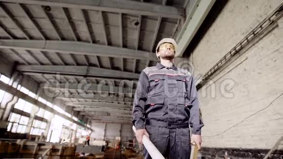 一个专业的工人手中握着一种精神站在一座大楼里在那里对旧建筑进行全球改造视频的预览图